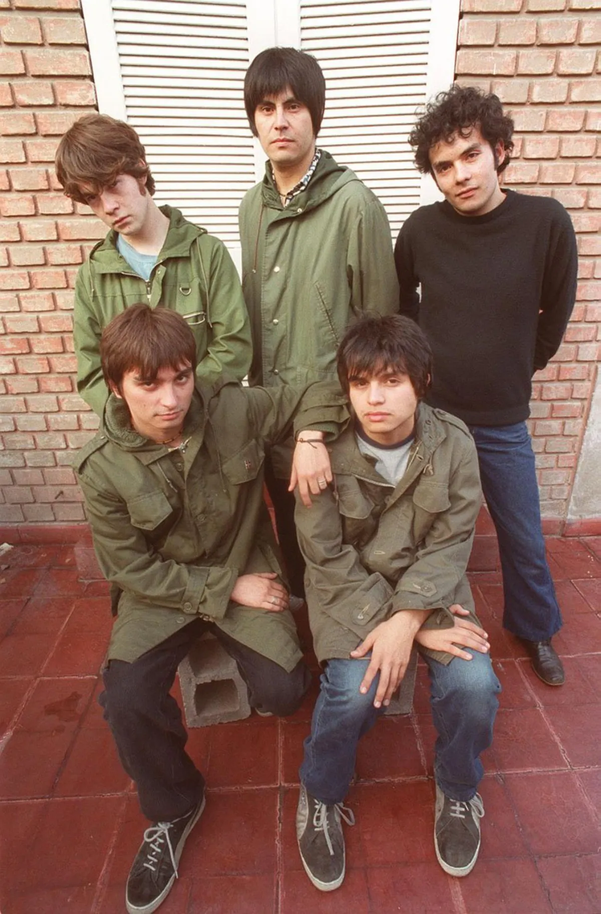 Los cinco integrantes de Los Bunkers con chaquetas verde militar en una foto de prensa