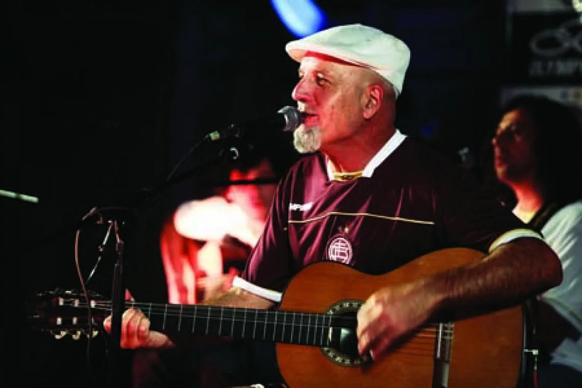 Gustavo Cordera cantando y tocando guitarra sobre un escenario