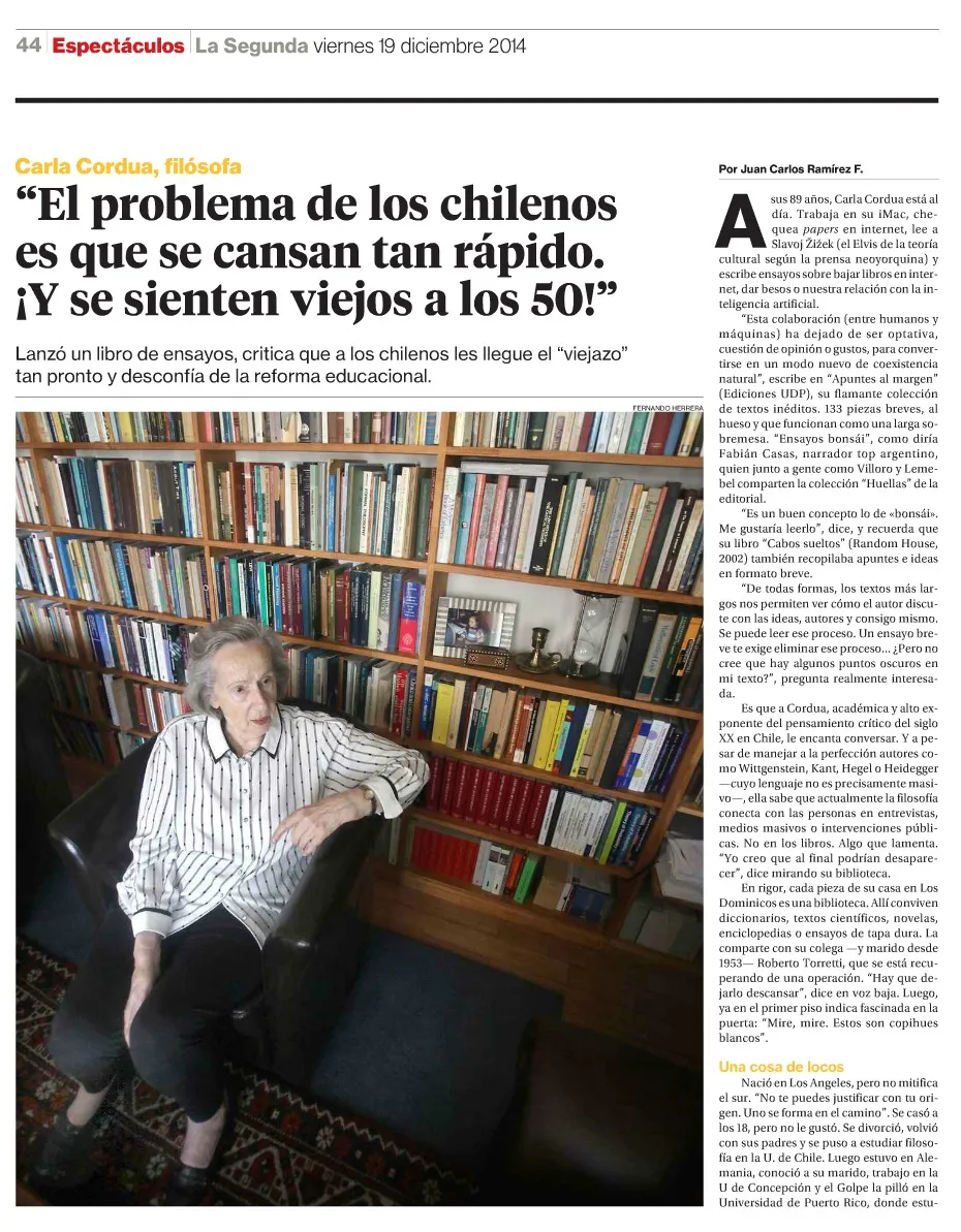 Página de Espectáculos de La Segunda con la entrevista a la filósofa Carla Cordua, fotografiada sentada frente a la enorme biblioteca de su casa