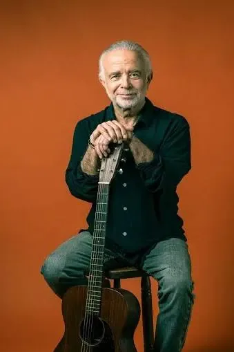Retrato de Fernando Ubiergo sentado con su guitarra